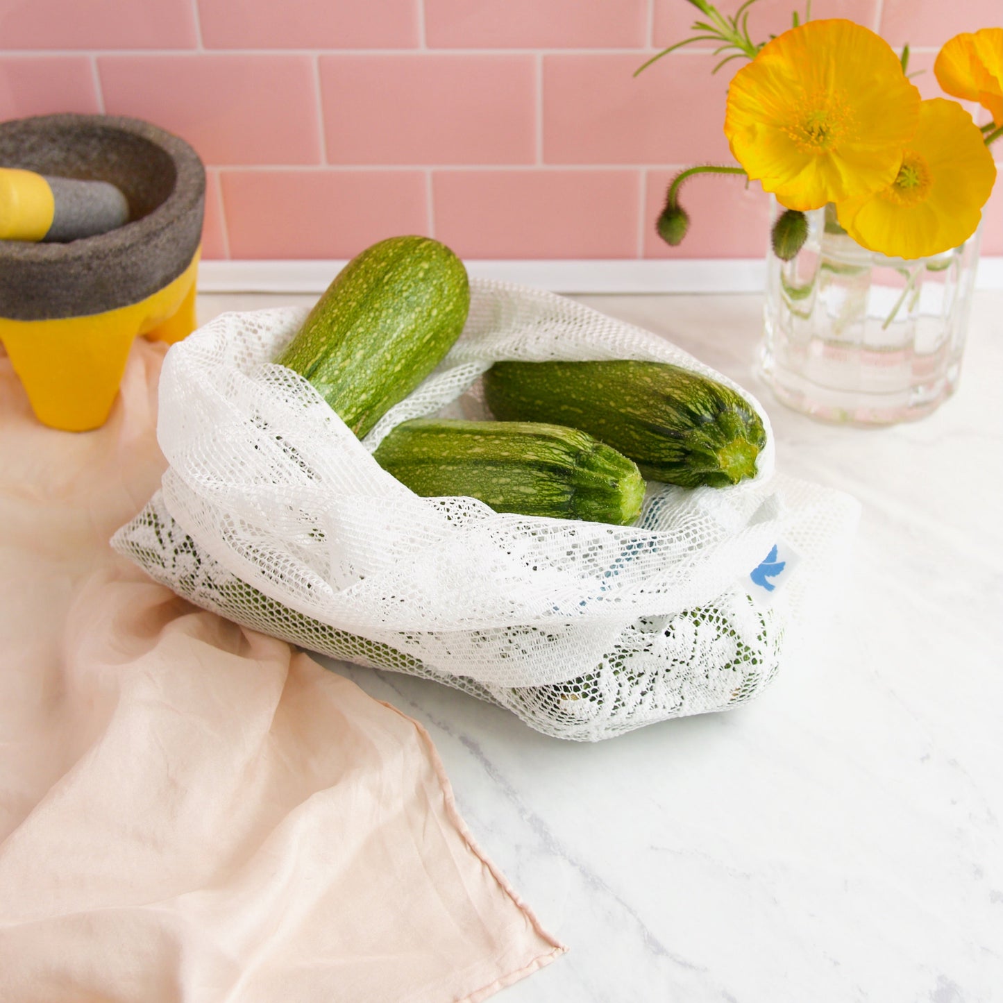 detail of reusable lace produce bag filled with zucchini