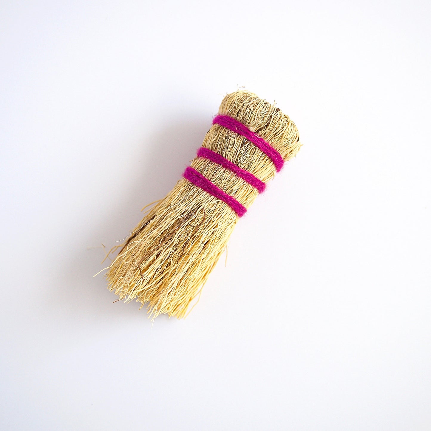 Escobeta de raiz Mexican dish scrubber made from plant roots wrapped in fucshia wool yarn