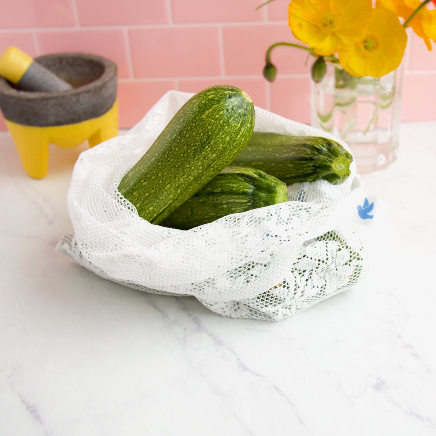 detail of reusable lace produce bag filled with zucchini